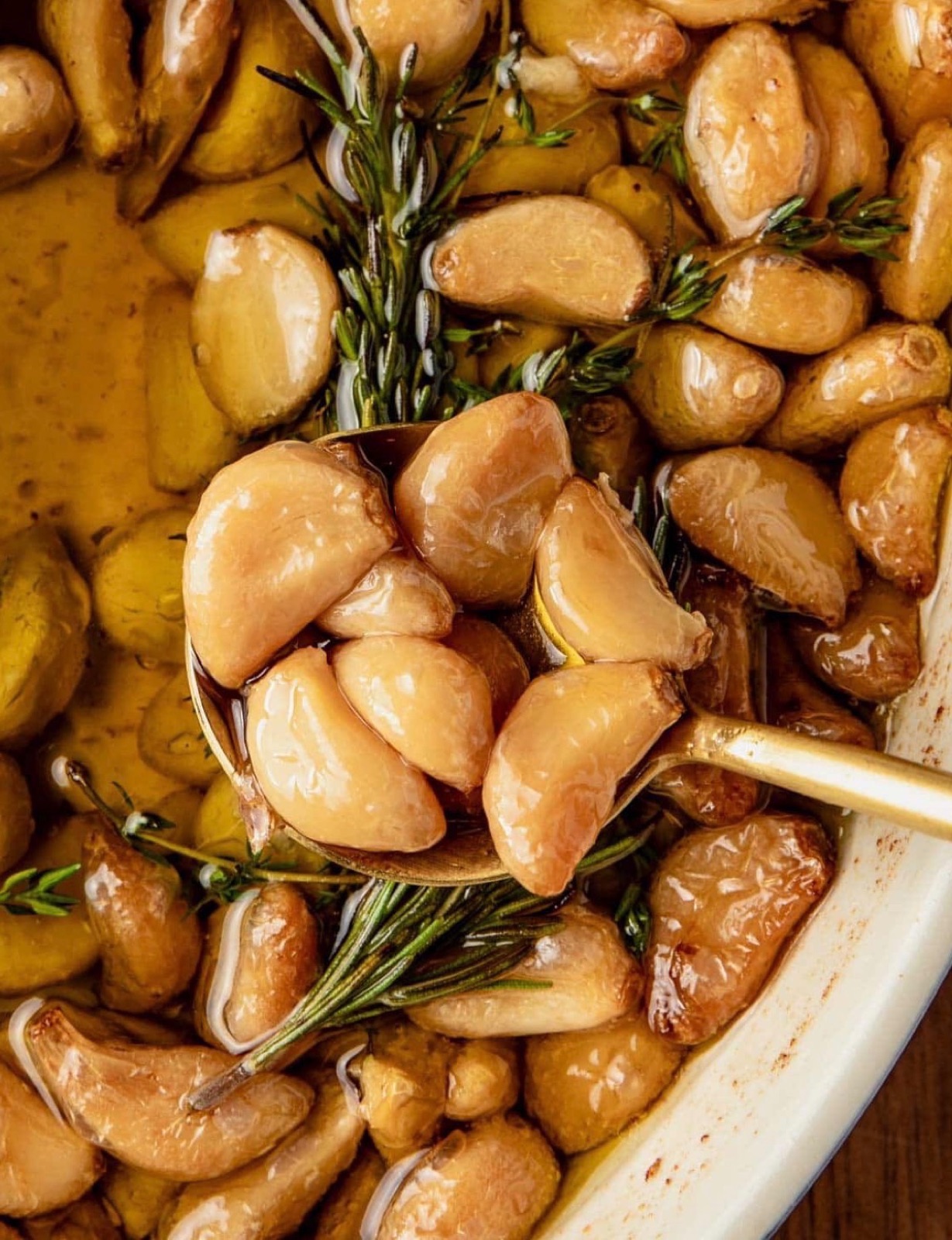 Golden cloves of garlic slow-confited in olive oil with rosemary and thyme